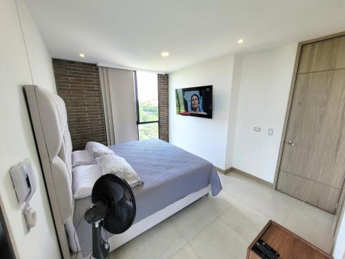 a bedroom with a bed with a fan and a window at Cali Piso 10 Pance Luxury Apartamento Sector Residencial, Confortable, Elegante Y Lujoso in Pance