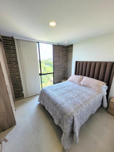 a bedroom with a large bed with a large window at Cali Piso 10 Pance Luxury Apartamento Sector Residencial, Confortable, Elegante Y Lujoso in Pance