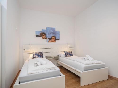 twee bedden in een kamer met witte muren bij Moderne stilvolle Wohnung im Herzen Münchens in München