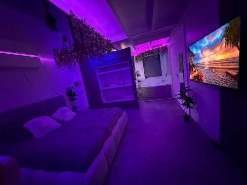 a purple room with a bed and a tv at Spartementen by Pure-Zen in Rotterdam