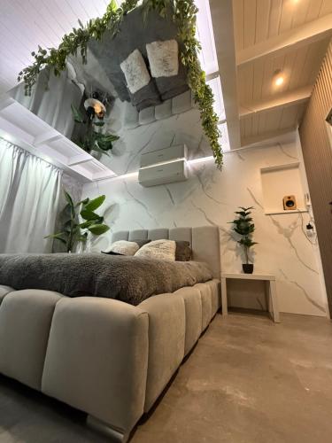 a living room with a couch and plants on the wall at Spartementen by Pure-Zen in Rotterdam