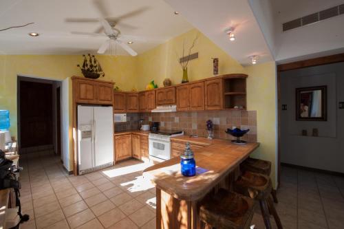 a kitchen with wooden cabinets and a white refrigerator at Villa Langosta by Cabo Villas in La Paz