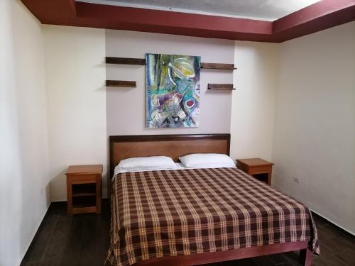a bedroom with a bed and a painting on the wall at Amplios y cómodos apartamentos en Playa del Carmen in Playa del Carmen