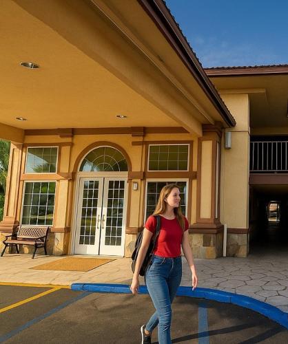 a woman walking in front of a building at Bposhtels Anaheim in Anaheim