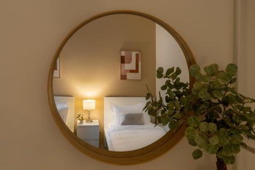 een spiegel in een slaapkamer met een bed en een plant bij 3BR Luxury Stay in Riyad