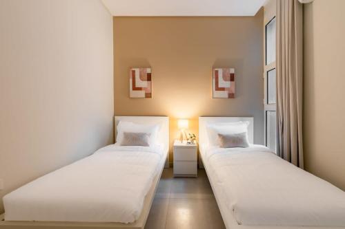 twee bedden in een kamer met een raam bij 3BR Luxury Stay in Riyad