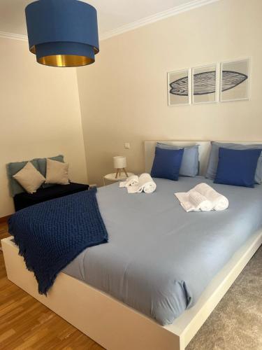 a bedroom with a large bed with blue pillows at Sea and Nature Escape in Furadouro