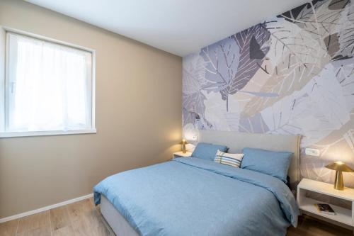 a bedroom with a blue bed and a large window at Lake View Apt - Only 15 min to Trento in Vignola