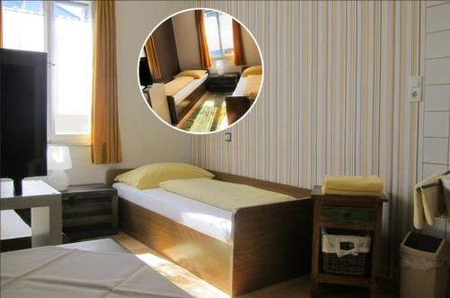 a small bedroom with a bed and a mirror at Pension Sonne Bed&Breakfast in Bregenz