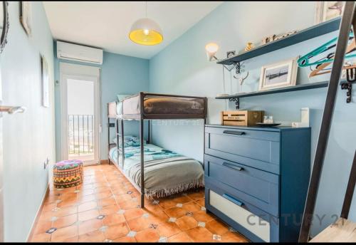 a bedroom with a bunk bed and a blue wall at Charming Coastal Retreat in Alboraya