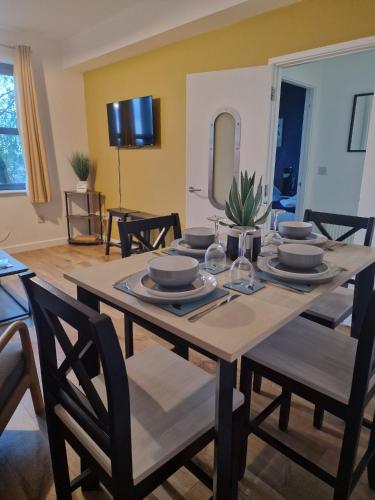 a dining room with a table with plates and glasses at Vibrant cosy 2 Bedroom Apartment in Coventry