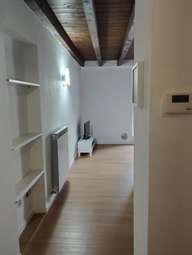 an empty room with a hallway with a television and a floor at Da Cocò in Udine