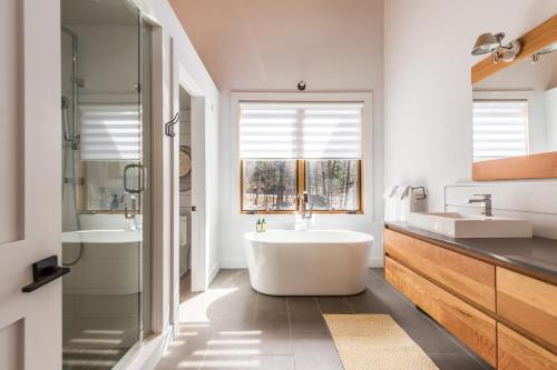 ein Badezimmer mit großer Badewanne und Waschbecken in der Unterkunft Chalet Trappeur Luxury Cottage Retreat with Hot Tub in Mont-Tremblant