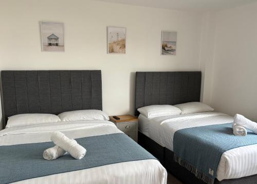two beds in a room with towels on them at Letterkenny Wild Atlantic Apartments in Letterkenny
