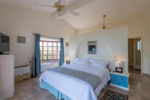 una camera da letto con un letto e un ventilatore a soffitto di Villa Sun Guadalupe by Cabo Villas a San José del Cabo