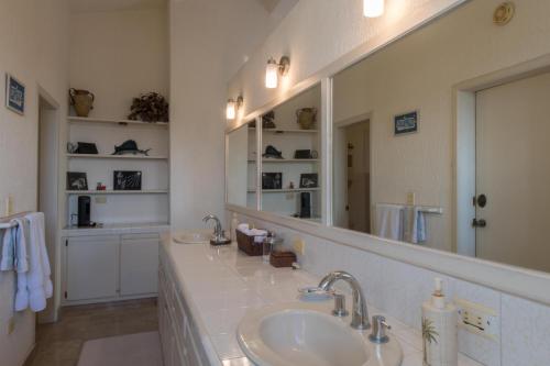 un bagno con un lavandino e un grande specchio di Villa Sun Guadalupe by Cabo Villas a San José del Cabo