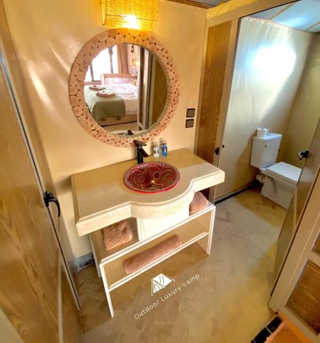 a bathroom with a sink and a mirror at Outdoor luxury camp in Merzouga