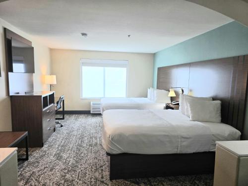 a hotel room with two beds and a television at Best Western Casa Villa Suites in Harlingen