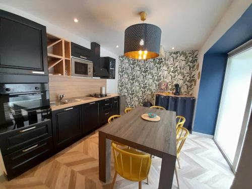 une cuisine avec une table en bois et des chaises jaunes dans l'établissement Maison de village rénovée au pied des alpilles, à Mollégès