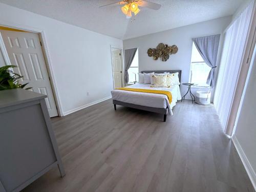 a white bedroom with a bed with a yellow blanket at Beautiful South-Facing Pool Home in Southern Dunes in Haines City