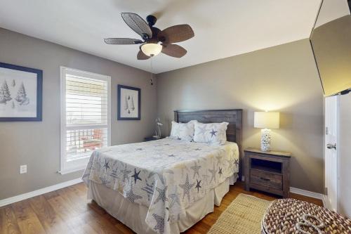 une chambre avec un lit et un ventilateur de plafond dans l'établissement A Wave From It All, à Dauphin Island