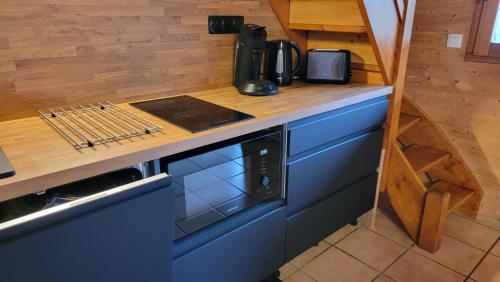 a kitchen with a counter with a stove top oven at Chalet 6 à 8pers pied des pistes, piscine et vue in Saint-François-Longchamp