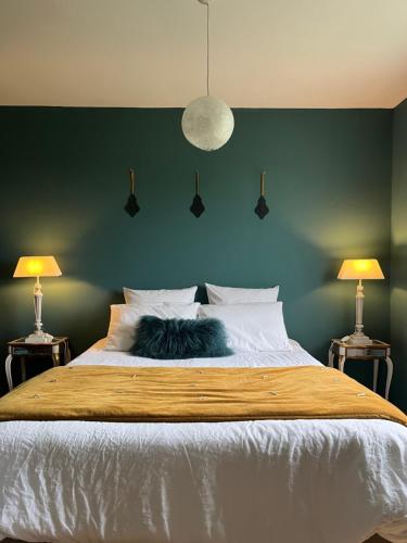 a cat sleeping on a bed with two lamps at SUITES EN PERCHE-Proche Mortagne in Bures