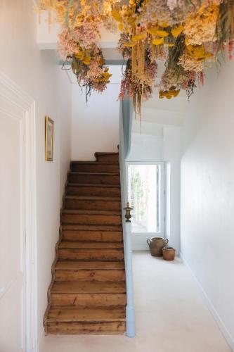 - un escalier dans une maison ornée de fleurs au plafond dans l'établissement Villa Réal, à Saint-Seurin-de-Cadourne