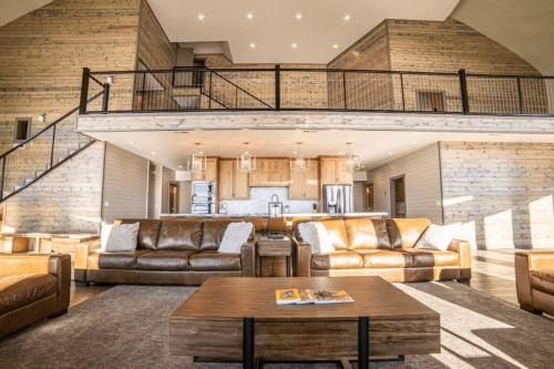 un soggiorno con divani in pelle e tavolo di West Cabin- Yellowstone Family Retreat- Sled Hill ad Ashton