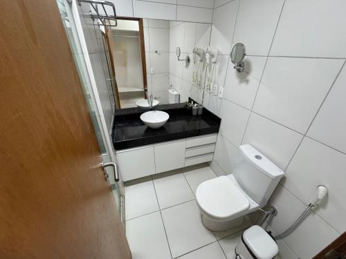une salle de bain avec toilettes, lavabo et miroir dans l'établissement The Experience Iloa Residenci, à Barra de São Miguel