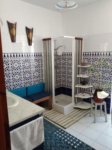 une salle de bain avec douche aux carreaux bleus et blancs dans l'établissement Maison Haute, à Moux-en-Morvan