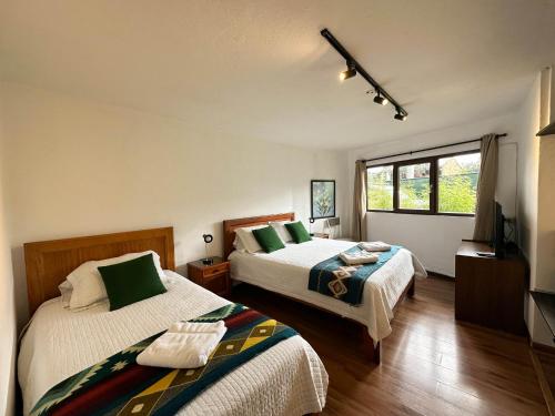Postel nebo postele na pokoji v ubytování Apartamentos Otorongo Cuenca Ecuador