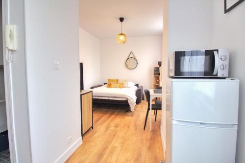 une chambre avec un réfrigérateur et une chambre avec un lit dans l'établissement L'Atelier maritime, Studio 2min Ferry & La Cité de la Mer, Cherbourg, Intendance Luxury Host, à Cherbourg en Cotentin