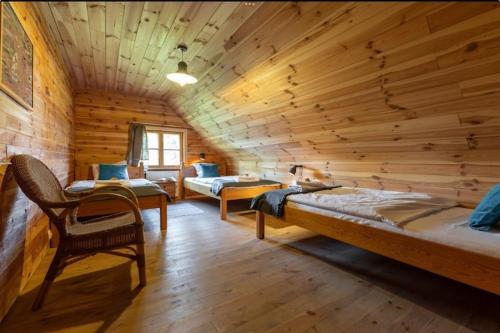 a room with two beds in a log cabin at Holiday Home in Be czna near Lake Kl pnicko in Bełzcna