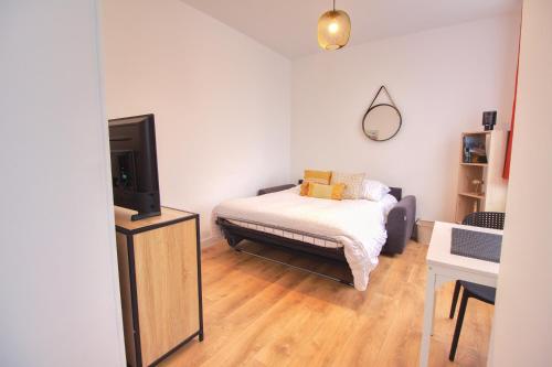 - une petite chambre avec un lit et une télévision dans l'établissement L'Atelier maritime, Studio 2min Ferry & La Cité de la Mer, Cherbourg, Intendance Luxury Host, à Cherbourg en Cotentin