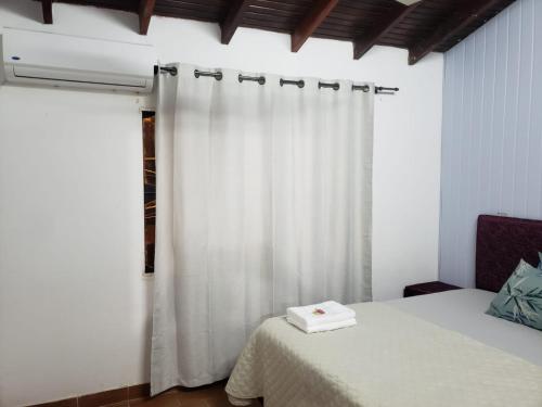 een slaapkamer met een bed en een wit gordijn bij Apartamento Vca Paraguay in Villarrica