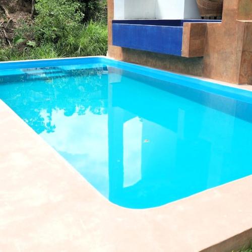 a swimming pool with blue water in front of a house at Casa La Kin in Cacahuatán