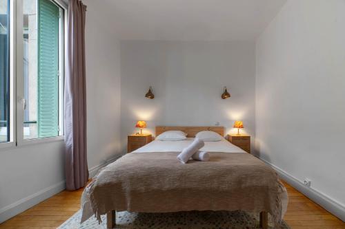 - une chambre blanche avec un grand lit et deux lampes dans l'établissement Le Thermale 2 - Appartement design, quartier Thermal, à Vichy