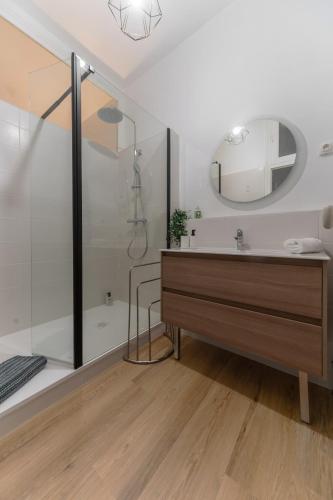une salle de bain avec un lavabo, une douche et un miroir dans l'établissement Le Thermale 2 - Appartement design, quartier Thermal, à Vichy