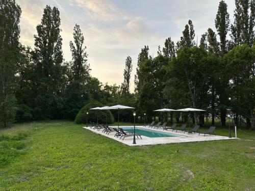 une piscine avec chaises et parasols dans l'établissement Domaine de Chevillons, à Chevillon-sur-Huillard