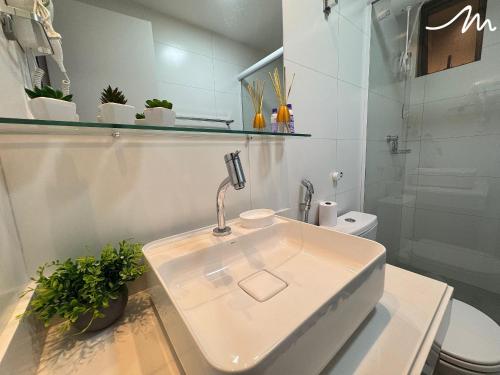 a white bathroom with a sink and a toilet at Vert House Jardim Oceania - Miramar Hospedagens in Tambaú