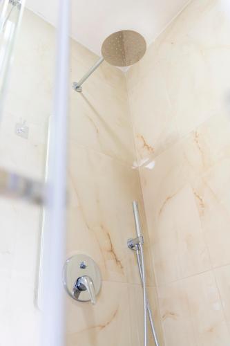 a shower with a shower head in a bathroom at Hotel Shkodra Comfort in Shkodër