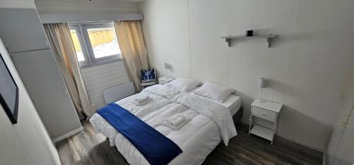 a small bedroom with a bed and a window at Øksfjord Hotel Norway in Øksfjord