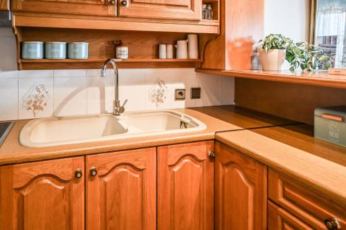a kitchen with a sink and wooden cabinets at Nisaki House in Skiathos