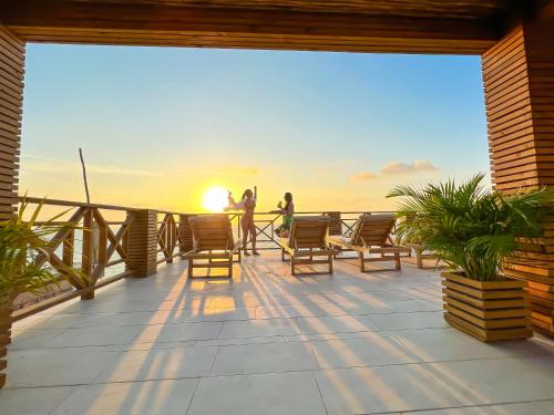 two people standing on a deck watching the sunset at Laguna Beach, Brisa Marina playa Frances in Coveñas