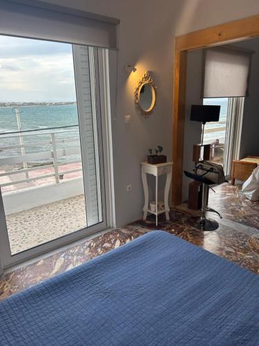 a bedroom with a large window with a view of the beach at appartment view sea artemida 2 in Artemida