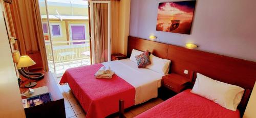 a hotel room with two beds and a window at Possidon in Agia Marina Aegina