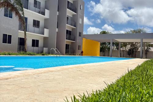a swimming pool in front of a building at New apartment with 3 bedrooms, for 6 persons & 7 min from Maya train in Cancún
