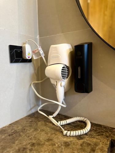 a hair dryer and a phone on a wall at Hotel y Cabañas Covemar in Coveñas