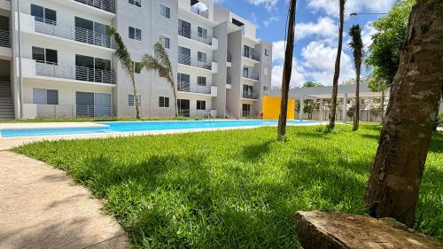 a large apartment building with a swimming pool in the grass at New apartment with 3 bedrooms, for 6 persons & 7 min from Maya train in Cancún